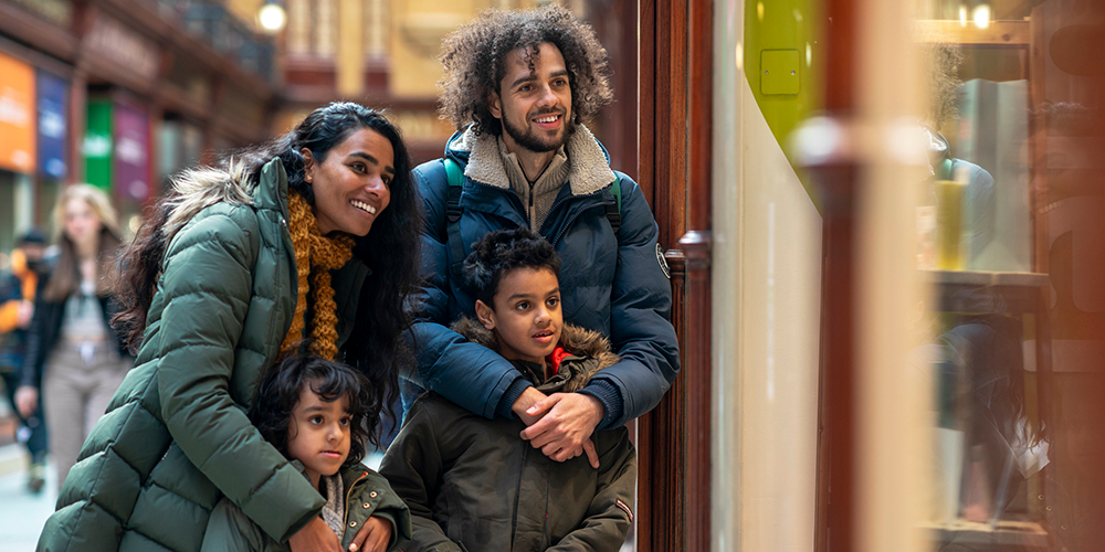 A family of four window shopping on a sunny winter day. A family of four window shopping on a sunny winter day.